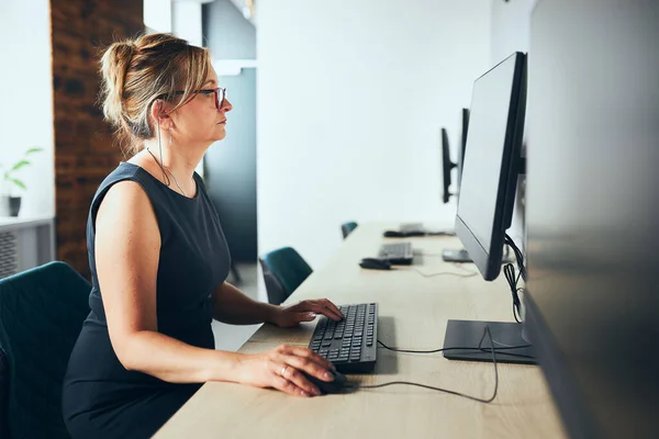 Ofiste Bilgisayarla Çalışan Endişeli Bir Kadını Bilgisayar Monitörünün Önündeki Masada — Stok fotoğraf