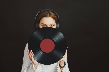 Elinde plak plağı tutan bir kadın. Müzik tutkusu. Analog kayıtlardan müzik dinlemek. Plak çalar üzerinde analog diskten müzik çalmak. Eski koleksiyonumdan müziğin tadını çıkarıyorum. Retro ve antika. Stereo sesi. Analog sesi