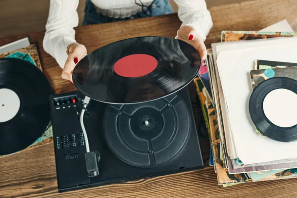 年轻女人在听黑胶唱机的音乐 在旋转唱机上播放音乐 在家里欣赏旧唱片收藏中的女歌手 一堆模拟乙烯记录 复古和复古音乐风格 音乐激情与爱好 — 图库照片
