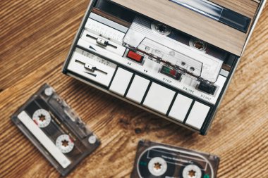 Küçük kasetler ve kaset kaydedici ahşap masada. Retro müzik tarzı. 80 'lerin müzik partisi. Eski tarz. Analog ekipmanları. Stereo sesi. Geçmişe dönelim.
