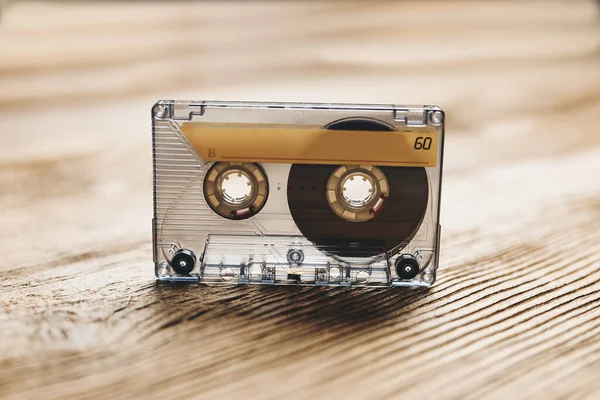 Tape cassette. Magnetic cassette tape on wooden table. Retro music style. 80s music party. Vintage style. Analog equipment. Stereo sound. Back to the past