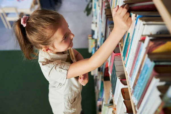 Schoolmeisje Kijkt Naar Boekenplank Schoolbibliotheek Slimme Meid Die Literatuur Kiest — Stockfoto