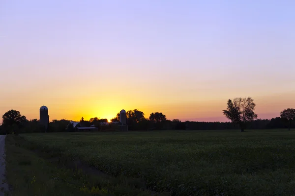 Maatila auringonlaskun aikaan — kuvapankkivalokuva