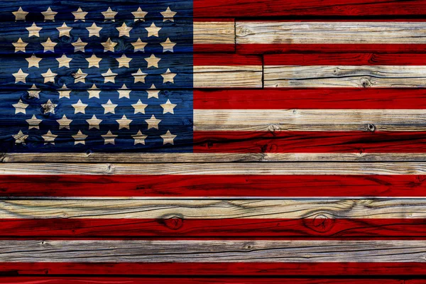 Старый окрашенный американский флаг на тёмном деревянном заборе — стоковое фото