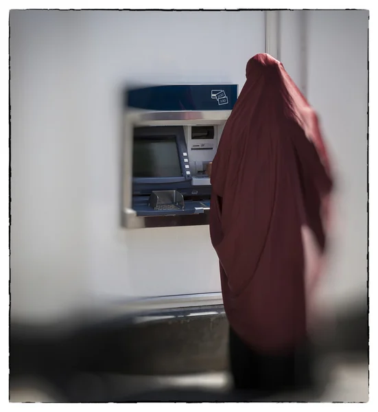 Muslimsk kvinna av cashpoint Stockbild