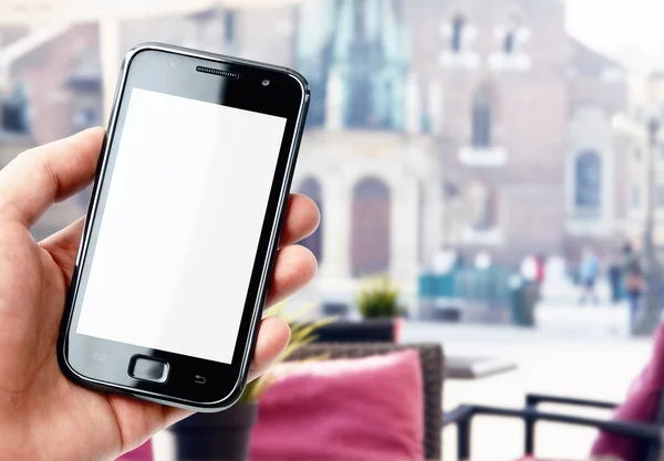 Hand holding smartphone in city cafe — Stock Photo, Image