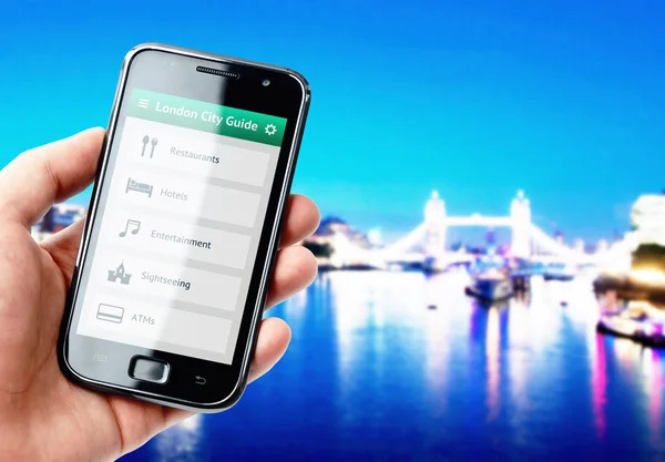Ruka držící smartphone s průvodce městem v Londýně — Stock fotografie