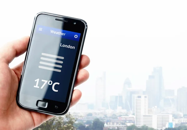 Рука держит смартфон с погодой в Лондоне — стоковое фото