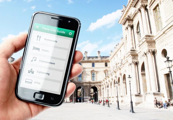 Tangan memegang smartphone dengan pemandu kota di Paris — Stok Foto