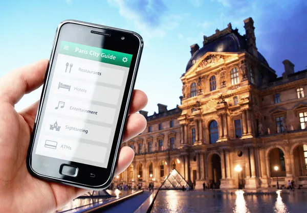 Ręka trzyma smartphone z przewodnik w Paryżu — Zdjęcie stockowe