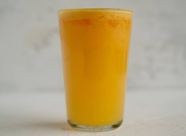 Beyaz arka planda bir bardak taze portakal suyu. Yemek fotoğrafı.