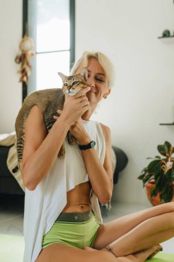 Bir kedi evdeki kadın eğitimini bölüyor. Kedisinin tadını çıkaran bir kadın. El bilgisayarı atışı