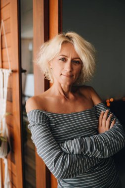 Evinde duran güzel sarışın bir kadının portresi.