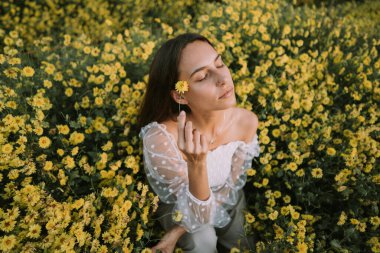 Genç ve çekici bir kadın Chiang Mai 'deki sarı çiçek tarlasında eğleniyor.