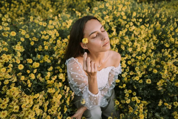Genç ve çekici bir kadın Chiang Mai 'deki sarı çiçek tarlasında eğleniyor.
