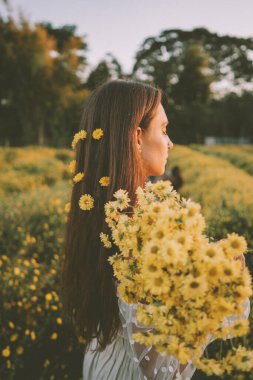 Genç ve çekici bir kadın Chiang Mai 'deki sarı çiçek tarlasında eğleniyor.