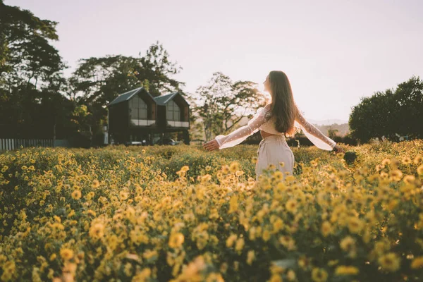 Genç ve çekici bir kadın Chiang Mai 'deki sarı çiçek tarlasında eğleniyor.