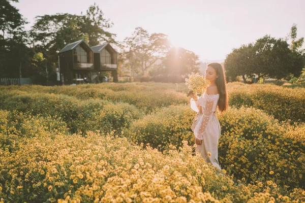 Genç ve çekici bir kadın Chiang Mai 'deki sarı çiçek tarlasında eğleniyor.