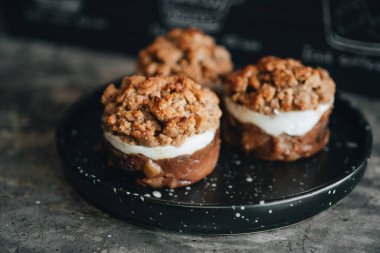 Elmalı tatlı siyah tabakta, arka planda.
