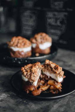 Elmalı tatlı siyah tabakta, arka planda.