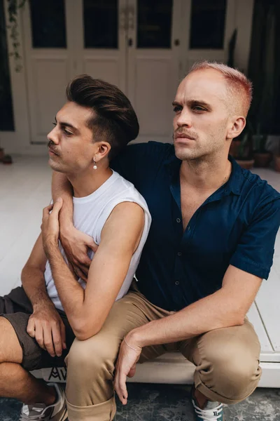 Gay Couple spend time together outdoors. Homosexual couple sitting outdoors