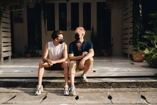 Gay Couple spend time together outdoors. Homosexual couple sitting outdoors