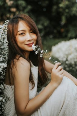 Portrait of thai woman sitting in white flower field