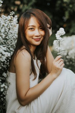 Portrait of thai woman sitting in white flower field