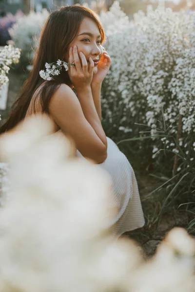 Portrait of thai woman sitting in white flower field