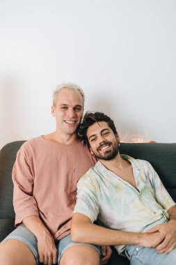 Gay couple sitting on sofa in their house