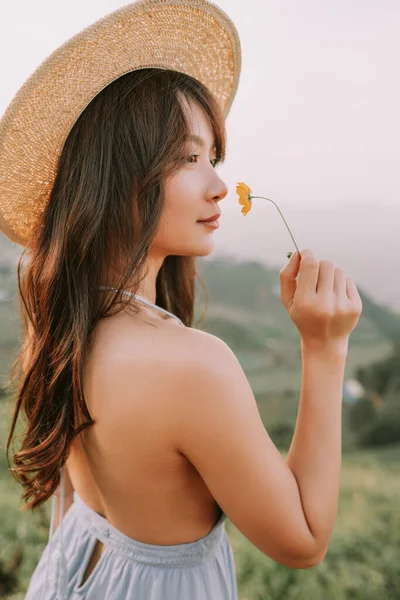 ジャムの山の花畑の帽子のアジアの幸せな若い女性の肖像画 — ストック写真