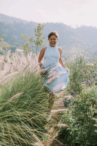 Thai woman is walking in flower field — Stockfoto