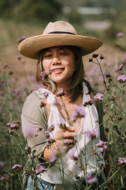 Taylandlı kadın çiçek tarlasında yürüyor.