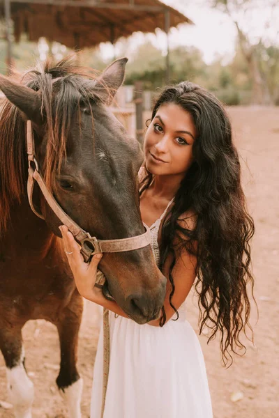 Woman in a white dress with a horse — стоковое фото