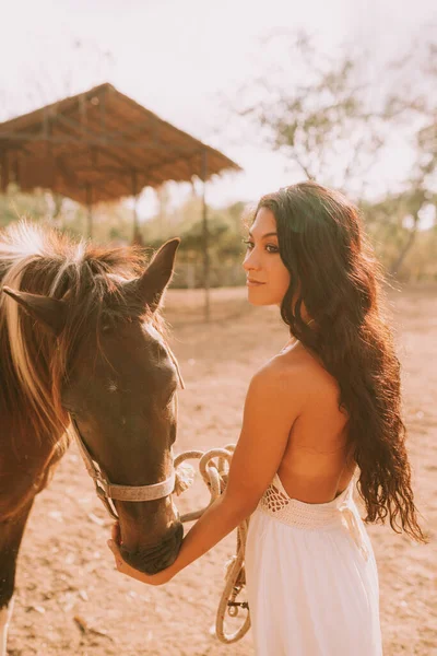 Woman in a white dress with a horse — Stockfoto