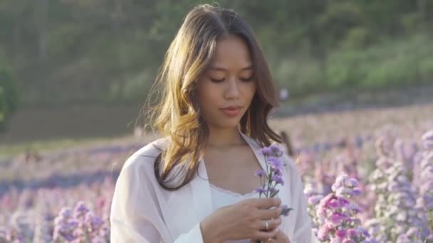 Щаслива тайська жінка, що розважається на квітковому полі. — стокове відео