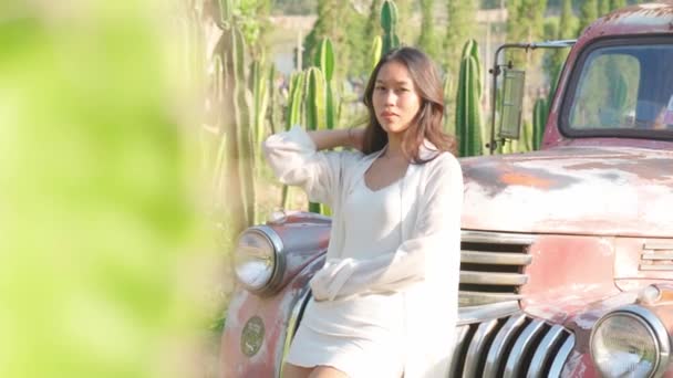 Thai young woman standing at retro car — Stockvideo