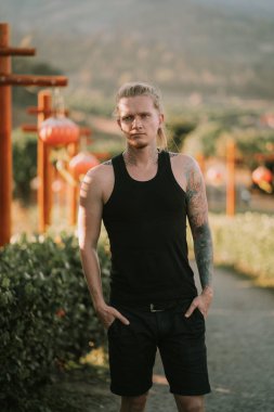 Dövmeli adam Pat Tayland 'da bir patikada Çin fenerleriyle dikiliyor.