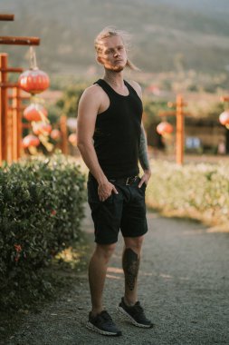 Dövmeli adam Yun Lai bakış açısında Çin fenerleriyle bir patikada duruyor.