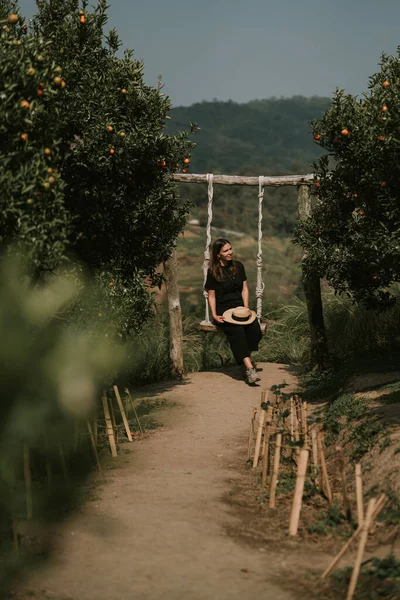 Woman is swinging on swings in orange farm in Mon Jam — Zdjęcie stockowe