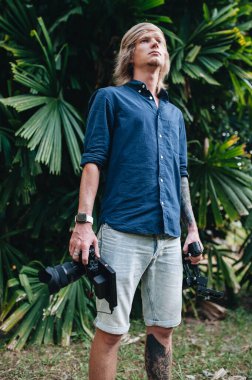 Kameraman dışarıda kamerasıyla ve vibratörüyle dikiliyor. Seçici odak