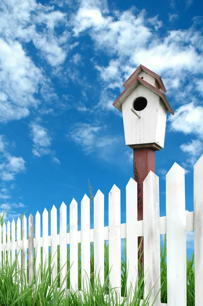 Recinzione in legno con erba verde e cielo blu — Foto Stock