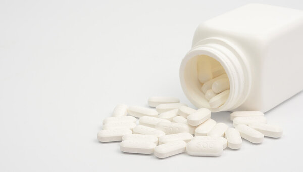 таблетки, разбросанные по пузырькам
