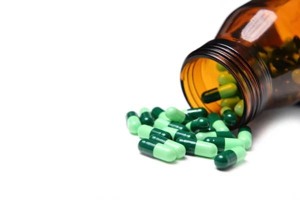 Gruppo di capsule medicinali verdi in bottiglia — Foto Stock