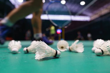 Yeşil badminton 'daki mekik arka planda oyuncuyla kort oynuyor