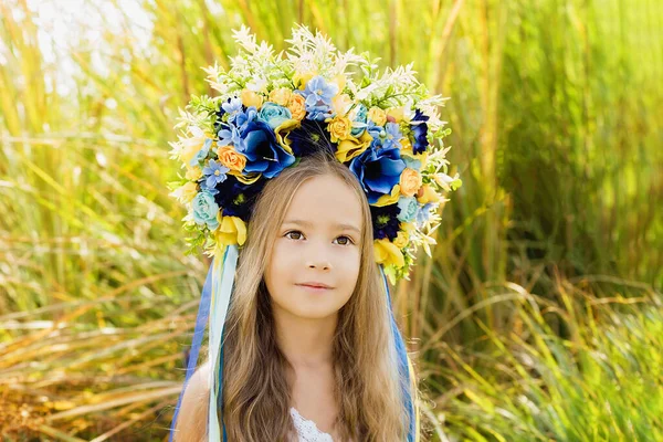 フィールド内のウクライナの頭の青と黄色のフラグ上の伝統的なウクライナの花輪の女の子 ウクライナの独立記念日 憲法の日だ 8月24日 愛国的な休日 — ストック写真