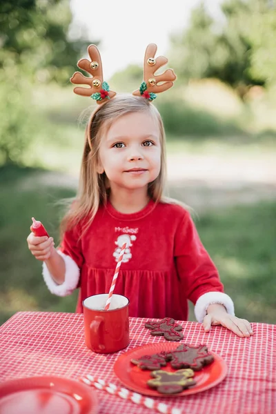 7月のクリスマス 子供は7月に木でクリスマスを待っています ホットココアをマシュマロとジンジャーで飲む女の子の肖像パン男のクッキー メリークリスマスとハッピーホリデー — ストック写真