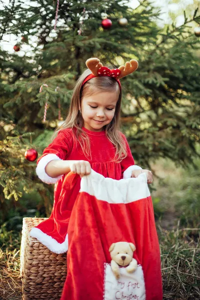 7月のクリスマス 子供は夏に木でクリスマスを待っています クリスマスツリーを飾る赤いドレスの少女の肖像画 冬休みや人の概念です メリークリスマスとハッピーホリデー — ストック写真