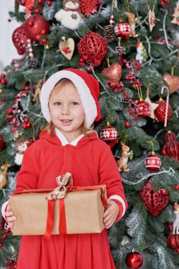 Mutlu heyecanlı kız çocuğu Noel hediyesi kutusunu tutuyor. Noel arifesinde heyecanlı küçük kız. Umut Noel Baba 'yı bekliyor. Umutlu çocuk. Yeni yıl arifesi. Hayaller gerçek olur..