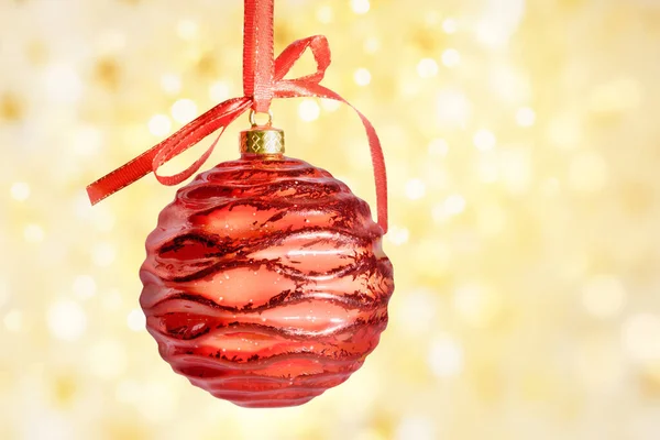 Palla di Natale rossa appesa al nastro con fiocco, su sfondo bokeh dorato con percorso di ritaglio. — Foto Stock